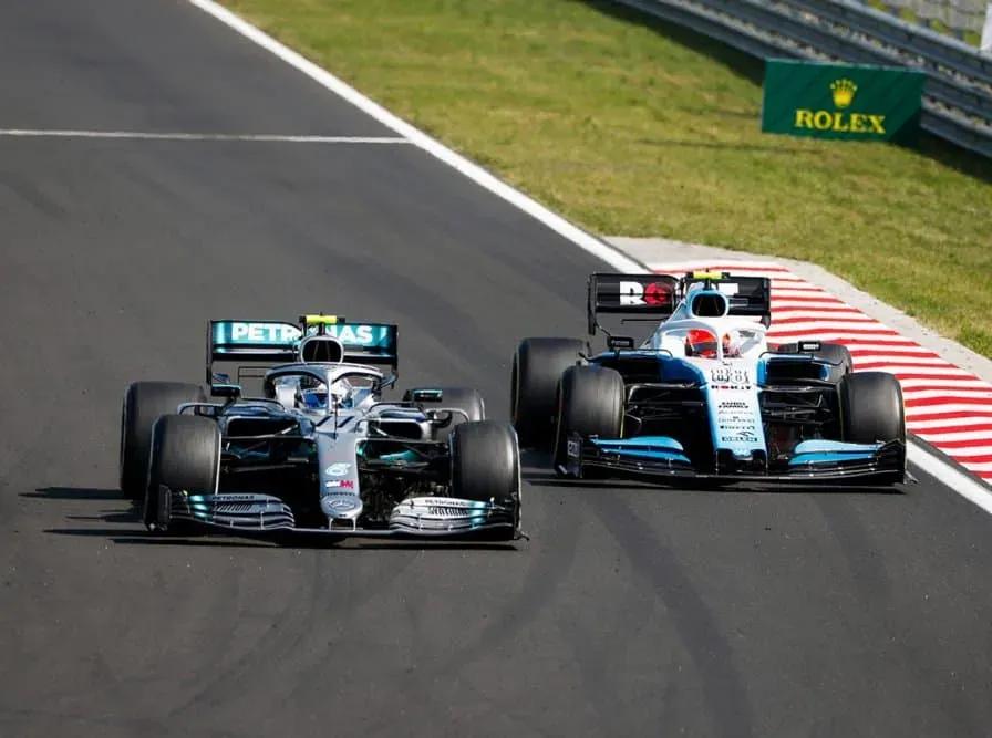 Two Formula 1 cars racing, a Mercedes leading a Williams